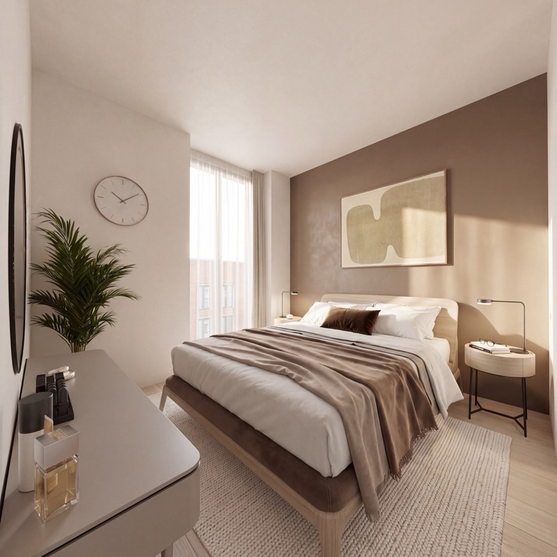 Impressie van de tweede slaapkamer met een taupe wand, een tweepersoonsbed, een kaptafel en een hoog raam.